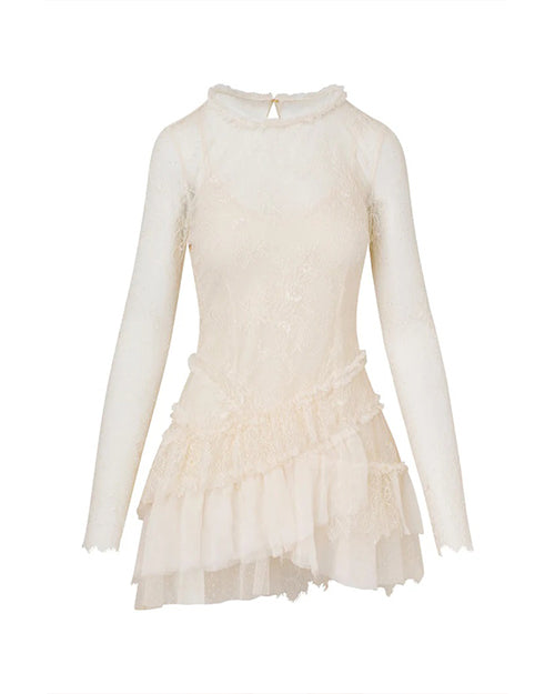 A white dress with a sheer layer over it, creating a sheer neckline and sleeves. The skirt is ruffled with a crisscross fabric design at the waist. The background is plain white.
