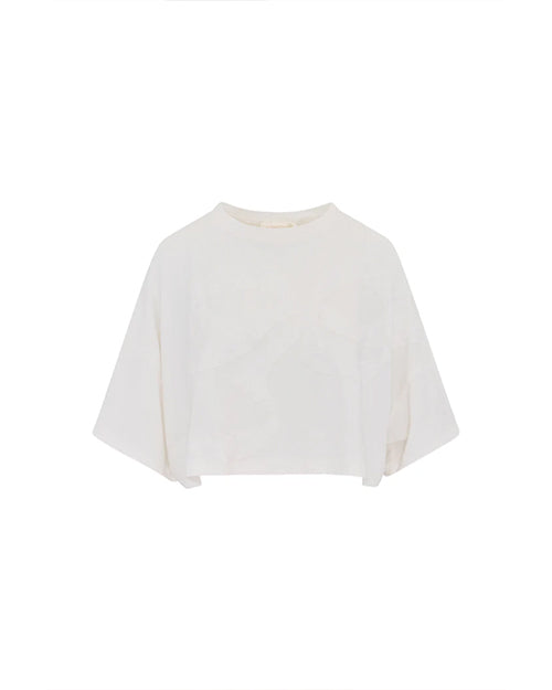 A cropped white, loose-fitting top placed against a white background. The sleeves are about the same length as the body.