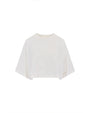 A cropped white, loose-fitting top placed against a white background. The sleeves are about the same length as the body.