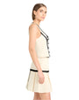 Side view Back view of a person in a sleeveless cream two piece set (skirt and top) with black zigzag trim, against a white background.
