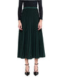 Person wearing a green pleated skirt on a white background
