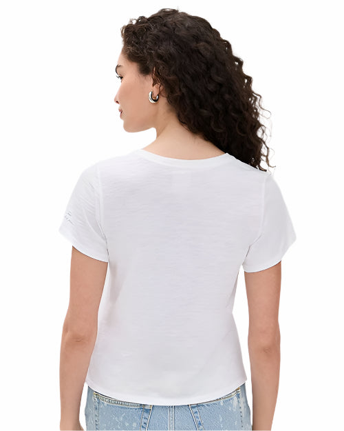 The backside view of a curly-haired model with her hair pushed to the side, wearing a white t-shirt. The shirt is worn with blue jeans and silver hoop earrings in front of a white background.