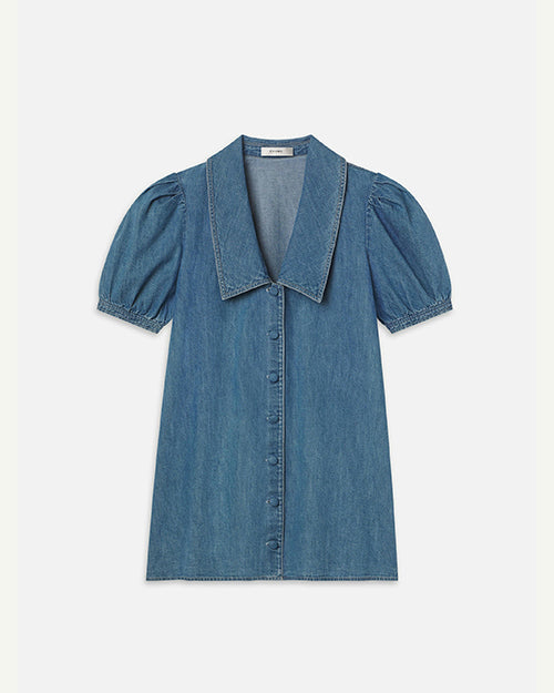 A blue denim dress with short, puffed sleeves, a large, pointed collar and denim buttons down the front, placed in front of a white background.