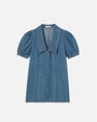 A blue denim dress with short, puffed sleeves, a large, pointed collar and denim buttons down the front, placed in front of a white background.