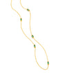 A gold necklace with a thin chain and small green rectangular gemstones spaced along the chain. The chain is half draped over a white background.