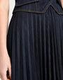 Close-up of a pleated navy skirt with a white background