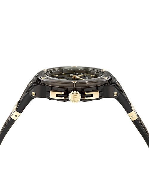A side view of a black transparent wristwatch with gold accents, including a gold crown with an engraved "F".  The background is plain white.