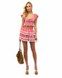 Person wearing a red and white checkered two-piece outfit with a ruffled short-sleeve top featuring a sweetheart neckline and bow detail, paired with a high-waisted tiered ruffle skirt, white platform ankle-strap sandals, and holding a brown handbag.