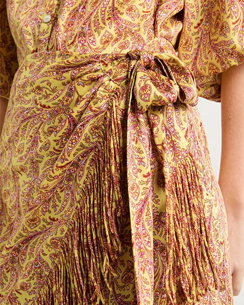 Close-up of a patterned dress with a tie waist.
