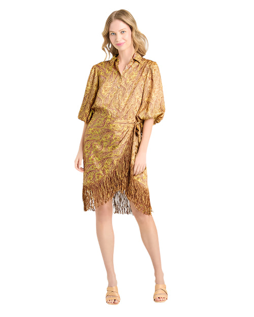 Person wearing a gold and brown patterned dress with a collar, three-quarter sleeves, and fringe hem paired with beige sandals.