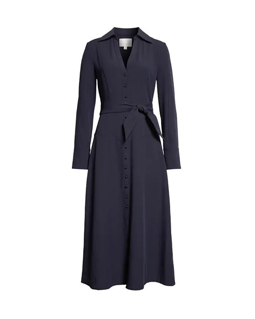 A navy long-sleeved button-down dress with a V-neck and a tied fabric bow at the waist. There is a large square tag in the inner neckline, and the dress is placed in front of a white background.