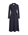 A navy long-sleeved button-down dress with a V-neck and a tied fabric bow at the waist. There is a large square tag in the inner neckline, and the dress is placed in front of a white background.