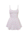 White dress with thin shoulder straps and a flared skirt, featuring a pattern of small tennis racket evenly distributed across the fabric.