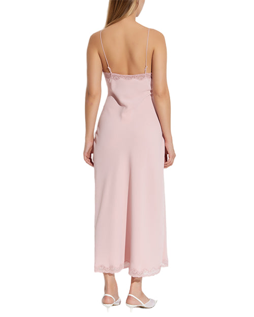 Back view of a pink slip dress worn by a model on a white background