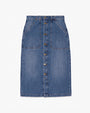 A long blue denim skirt with gold buttons down the front and two large, slanted pockets on either side. The skirt is placed against a white background.