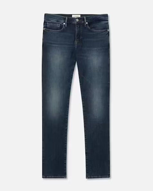 A full shot of a pair of dark jeans with a faded wash on the thighs and knees. The background is plain white.