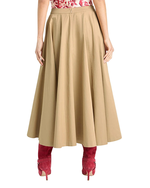 Back view of a person wearing a beige skirt  and red boots on a white background
