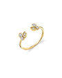 A gold ring with an open center design, featuring leaf-shaped decorative elements and diamonds on each end. The background is plain white.