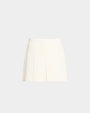 White short shorts with a front pleat sitting in front of a plain white background.