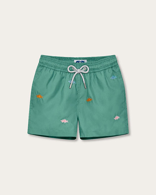 A pair of green swim shorts with an elastic waistband and white drawstrings, featuring an embroidered pattern of multicolored sea flowers. The background is white.