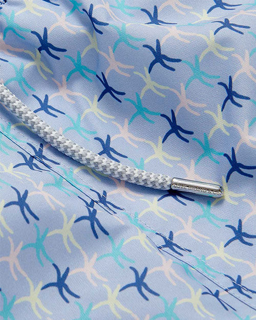 A close-up view of a pair of blue and white striped starfish patterned swim shorts with a grey drawstring.