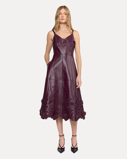 Front view of a woman wearing a purple dress with floral details on a white background