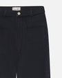 A closeup front view of a pair of navy denim jeans with a gold button. The jeans have zipper and button closure, two large front pockets, and a label reading FRAME.