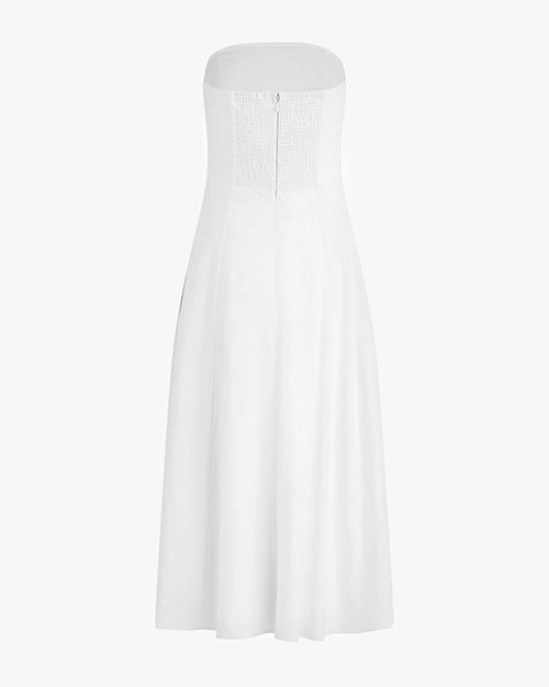 The backside view of a long, strapless white dress with a partially open back with an elastic material and a zipper. The background is white.