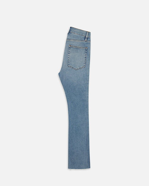 An overhead shot of a half folded pair of light blue denim jeans placed against a white background.