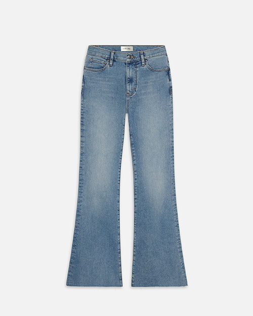 A pair of light blue denim jeans with flared legs, and a slightly worn look, placed in front of a white background. The inner waistline has a white tag.