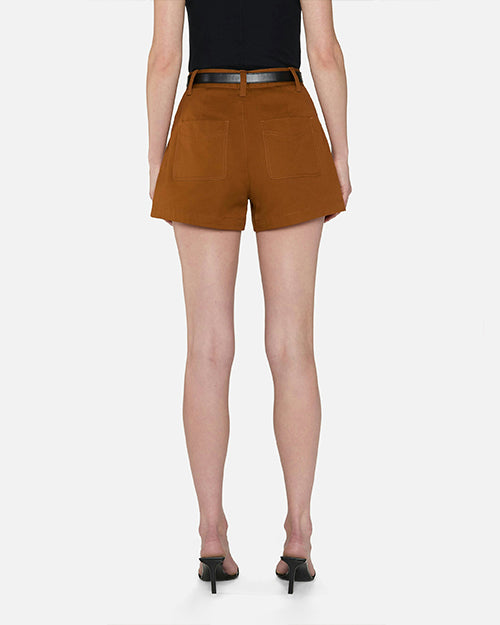 A lower-body backside view of a model wearing a black top tucked into high-waisted brown shorts with two large back pockets and a black belt held by single belt loops. The model is also wearing black heels, and she is standing against a white background.