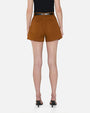 A lower-body backside view of a model wearing a black top tucked into high-waisted brown shorts with two large back pockets and a black belt held by single belt loops. The model is also wearing black heels, and she is standing against a white background.