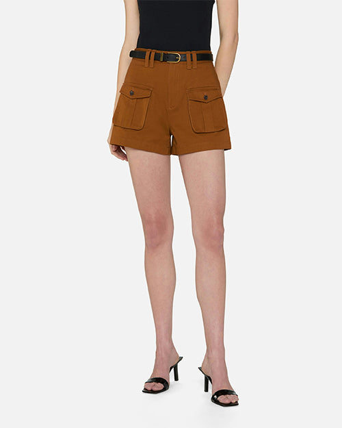 A lower body shot of a model wearing a black top tucked into high-waisted brown shorts with two large front pockets featuring flap closure with black buttons, and a thin black belt held by double belt loops. The model is also wearing black open toe heels and is standing against a white background.