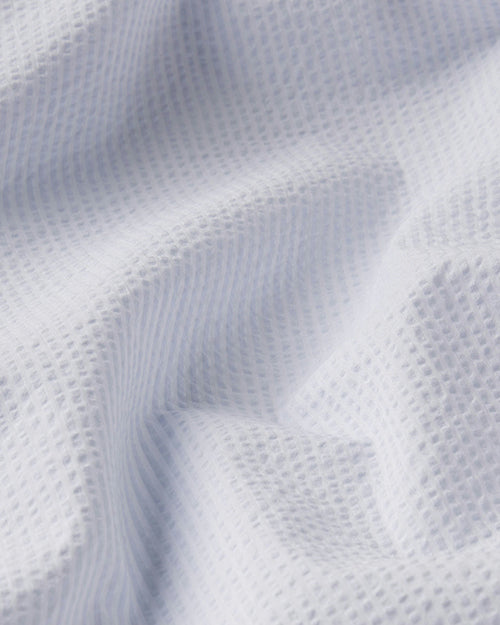 A close-up image of white and light blue striped fabric.