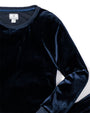 A close-up view of a navy velvet long-sleeved top with a square white tag in the inner neckline.