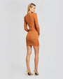 A full body backside view of a blonde model with her hair swept to the side, wearing an orange long sleeve dress with a ribbed material, a V-neck and gold buttons. The model is accessorizing with gold earrings, a gold clutch and gold pointed-toe heels.