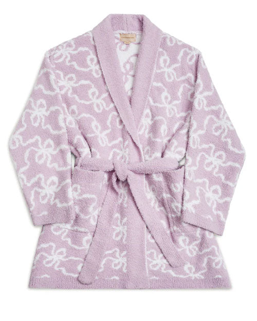 A soft purple bathrobe with a thin white bows pattern. The bathrobe has long sleeves, a shawl collar, and a matching pink belt tied around the waist, placed behind a white background.