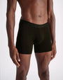 A close-up image of a model wearing a pair of black boxer briefs standing against a white background.