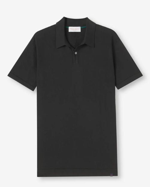 A black polo-shirt with a rectangular white tag in the inner neckline. The shirt is placed in front of a white background.
