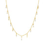 A gold chain necklace with small evenly spaced hanging double crystals. The necklace is hanging over a chain background.