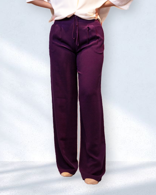 Model wearing purple silk trousers with adjustable waistband and pockets.