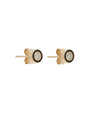 A sideview of a pair of gold stud earrings with a black enamel circular design and a diamond in the middle, angled to show butterfly earring backings attached. The background is plain white.