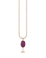 A rose gold chain with a wine glass pendant adorned with purple gems. The chain is hanging over a white background.