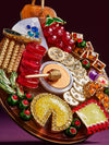  A decorative Christmas ornament showcasing a variety of food items, such as candies, fruits, and holiday snacks