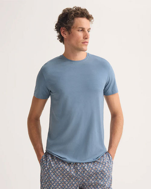 The model showcases a blue t-shirt paired with shorts.