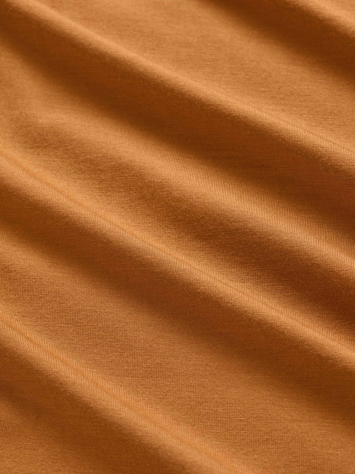Close-up of a plain orange fabric, showcasing its texture and color variations.