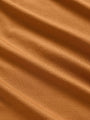 Close-up of a plain orange fabric, showcasing its texture and color variations.