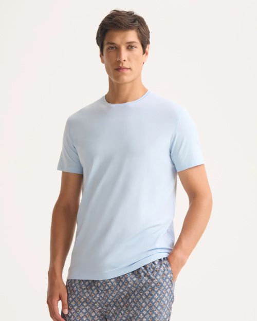 A man wearing a light blue T-shirt and patterned pants, showcasing a blend of comfort and understated elegance.