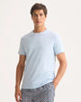 A man wearing a light blue T-shirt and patterned pants, showcasing a blend of comfort and understated elegance.