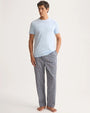  A man in a blue T-shirt paired with patterned pants, embodying casual comfort and stylish simplicity.